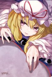 Rule 34 | 1girl, absurdres, artist name, blonde hair, commentary request, crawling, dress, eyes visible through hair, fingernails, gap (touhou), hat, hat ribbon, highres, long hair, looking at viewer, lying, mob cap, on stomach, parted lips, purple eyes, red ribbon, ribbon, smile, solo, tabard, touhou, upper body, white dress, white hat, yakumo yukari, yonoisan