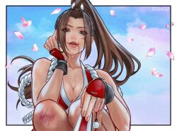 1girl ai_shou artist_name border breasts brown_eyes brown_hair character_name cleavage commentary english_commentary fatal_fury from_below hand_fan highres holding holding_fan long_hair petals ponytail scraped_knee shiranui_mai solo street_fighter street_fighter_6 white_border