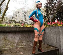 Rule 34 | 1girl, blonde hair, bodysuit, boots, breasts, cammy white, cammy white (cosplay), capcom, cosplay, day, gloves, legs, leotard, looking at viewer, photo (medium), solo, standing, street fighter, tagme, tree
