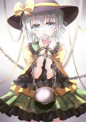 Rule 34 | 1girl, black hat, blouse, blurry, blurry background, bound, bound wrists, bow, chain, commentary, covered mouth, covering own mouth, cowboy shot, dise (psychoro), fingernails, frilled shirt collar, frilled skirt, frilled sleeves, frills, green eyes, green nails, green skirt, hair between eyes, hands up, hat, hat bow, highres, komeiji koishi, light blush, light green hair, long sleeves, nail polish, shirt, short hair, skirt, solo, third eye, touhou, wide sleeves, yellow bow, yellow shirt
