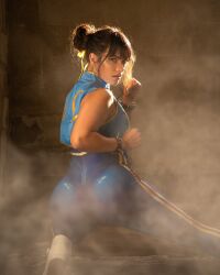 Rule 34 | 1girl, alternate costume, ass, bodysuit, breasts, capcom, chun-li, chun-li (cosplay), clenched hands, cosplay, double bun, dust, fighting stance, hair bun, highres, huge ass, photo (medium), simple background, sitting, skin tight, small breasts, street fighter, street fighter zero (series), thighs, zoogirlq