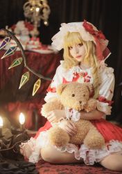 Rule 34 | 1girl, blonde hair, bow, candle, candlestand, closed mouth, commentary request, cosplay, cosplay photo, crystal, eyelashes, fingernails, flandre scarlet, flandre scarlet (cosplay), frilled shirt collar, frilled skirt, frills, gem, hat, hat bow, highres, holding, holding stuffed toy, knees, koiyume615, light blush, looking at viewer, mob cap, on floor, one side up, photo (medium), red bow, red carpet, red eyes, red gemstone, red neckwear, red ribbon, red skirt, red vest, ribbon, short hair, short sleeves, side ponytail, sitting, skirt, solo, stuffed animal, stuffed toy, table, tablecloth, teddy bear, touhou, vest, wariza, white hat, wings, wrist cuffs