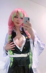 1girl belt black_skirt braid breasts cellphone cleavage cosplay cosplay_photo female_focus gradient_hair green_eyes green_hair hair_between_eyes haori highres instagram_username japanese_clothes kanroji_mitsuri kanroji_mitsuri_(cosplay) kimetsu_no_yaiba large_breasts long_sleeves matching_hair/eyes mole mole_under_each_eye mole_under_eye multicolored_hair multiple_moles nyanpiree phone photo_(medium) pink_hair realistic selfie skirt smartphone smile solo twitter_username two-tone_hair