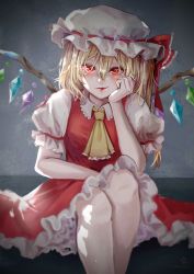Rule 34 | 1girl, ascot, blonde hair, blouse, closed mouth, collared shirt, commentary, crystal, feet out of frame, flandre scarlet, frilled ascot, frilled shirt collar, frilled skirt, frilled sleeves, frills, glowing, glowing eyes, grey background, hair between eyes, hand on own cheek, hand on own face, happy, hat, hat ribbon, highres, hoshiringo0902, legs, lips, looking at viewer, medium hair, mob cap, puffy short sleeves, puffy sleeves, red eyes, red lips, red ribbon, red skirt, red vest, ribbon, ribbon-trimmed headwear, ribbon trim, shirt, short sleeves, side ponytail, sitting, skirt, smile, solo, touhou, vest, white hat, white shirt, wings, yellow ascot