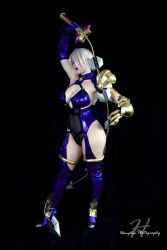 Rule 34 | 1girl, absurdres, armor, bellechere, blue eyes, breasts, claws, cleavage, cosplay, cosplay photo, dark, gloves, hair over one eye, highres, isabella valentine, isabella valentine (cosplay), large breasts, photo (medium), short hair, skin tight, solo, soul calibur, soulcalibur, soulcalibur ii, weapon, whip sword, white hair