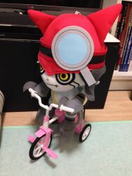 Rule 34 | appmon, claws, digimon, fang, gatchmon, hat, helmet, highres, magnifying glass, photo (medium), solo, stuffed toy, tail, tricycle, yellow eyes