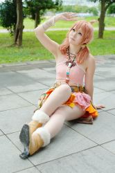 Rule 34 | 1girl, belt, boots, bracelet, cosplay, female focus, final fantasy, final fantasy xiii, grass, jewelry, midriff, necklace, oerba dia vanille, oerba dia vanille (cosplay), on floor, outdoors, pink shirt, shirt, sitting, skirt, solo, tiles, tree, twintails