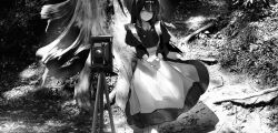 Rule 34 | 1girl, antique camera, apron, branch, bush, dappled sunlight, dress, feet out of frame, forest, grass, greyscale, hair between eyes, highres, juliet sleeves, legs together, long dress, long hair, long sleeves, looking at viewer, maid, misumigumi, monochrome, nature, original, outdoors, own hands together, plant, puffy sleeves, sidelocks, solo, straight hair, sunlight, tree, tripod