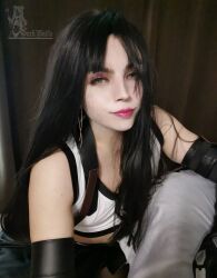 Rule 34 | 1boy, androgynous, black gloves, black hair, cosplay, crossdressing, darkwaifutrap, elbow gloves, final fantasy, final fantasy vii, final fantasy vii remake, gloves, green eyes, lips, long hair, looking at viewer, miniskirt, non-web source, photo (medium), pink lips, real life, simple background, skirt, smile, solo, straight hair, sweat, tank top, tifa lockhart, tifa lockhart (cosplay), trap, white tank top