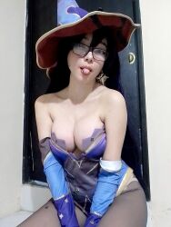 Rule 34 | 1girl, bare shoulders, breasts, cleavage, cosplay, door, female focus, genshin impact, glasses, hat, highres, indoors, kneeling, large breasts, looking at viewer, mexican (nationality), mona (genshin impact), mona (genshin impact) (cosplay), oz cosplay, photo (medium), solo, tongue, tongue out, witch hat