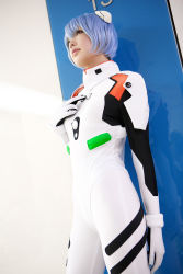 Rule 34 | 1girl, asian, ayanami rei, blue hair, color contacts, cosplay, cowboy shot, dutch angle, hairpods, highres, namada, neon genesis evangelion, parted lips, photo (medium), plugsuit, red eyes, short hair, solo, standing