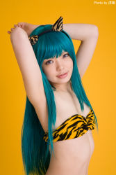 Rule 34 | 1girl, animal print, aqua hair, armpits, arms up, asian, bikini, blue hair, breasts, color contacts, cosplay, fake horns, happy, highres, horns, indoors, light smile, long hair, looking at viewer, lum, lum (cosplay), namada, photo (medium), purple eyes, simple background, small breasts, solo, standing, strapless, strapless bikini, swimsuit, tiger print, upper body, urusei yatsura, yellow background