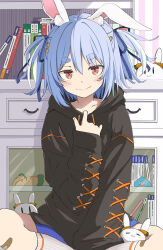 Rule 34 | 1girl, absurdres, alternate costume, animal ear fluff, animal ears, black hoodie, blue hair, blue ribbon, blush, book, carrot hair ornament, chest of drawers, closed mouth, collarbone, commentary, el (nevelo), feet out of frame, food-themed hair ornament, hair between eyes, hair ornament, hair ribbon, hand up, highres, hololive, hood, hood down, hoodie, hoodie pull, indian style, long sleeves, looking at viewer, pekomon (usada pekora), orange eyes, rabbit-shaped pupils, rabbit ears, ribbon, short hair, sitting, sleeves past wrists, socks, solo, straight-on, stuffed carrot, symbol-shaped pupils, thick eyebrows, two side up, usada pekora, virtual youtuber, white socks