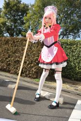 Rule 34 | 1girl, apron, asian, black footwear, blurry, breasts, broom, cosplay, depth of field, dress, dutch angle, garter straps, hedge, highres, light smile, looking at viewer, maid, maid apron, makeup, mary janes, mascara, namada, nono (top wo nerae 2!), outdoors, parking lot, photo (medium), pigeon-toed, pink hair, puffy sleeves, shoes, short dress, sidelocks, small breasts, solo, standing, thighhighs, top wo nerae 2!, tree, white thighhighs, zettai ryouiki