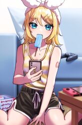 Rule 34 | 1girl, between legs, black shorts, blue eyes, bow, breasts, cellphone, collarbone, controller, couch, dolphin shorts, fangs, food, food in mouth, game controller, hair between eyes, hair bow, hair ornament, hairband, hairclip, hand between legs, handheld game console, highres, holding, holding phone, kagamine rin, light blush, looking at viewer, melting, mouth hold, nintendo switch, number tattoo, phone, pillow, popsicle, shirt, short hair, shorts, shoulder tattoo, sitting, sleeveless, sleeveless shirt, small breasts, solo, soramame pikuto, striped clothes, striped shirt, swept bangs, tank top, tattoo, vocaloid, wariza, white bow, yellow shirt