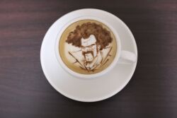 Rule 34 | 1boy, absurdres, afro, black hair, brown theme, cafe, coffee cup, cup, disposable cup, dragon ball, dragonball z, highres, latte art, latte art (medium), long mustache, looking ahead, male focus, mr. satan, mustache, photo (medium), receding hairline, smile, solo, table, thick eyebrows, tokoroten 1234, unconventional media, wrinkled skin