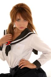 Rule 34 | 1girl, brown hair, cosplay, dyed hair, hand on own hip, leah dizon, looking at viewer, photo (medium), sailor, school uniform, serafuku, simple background, solo, twintails, white background
