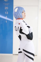 Rule 34 | 1girl, asian, ayanami rei, blue hair, color contacts, cosplay, cowboy shot, hairpods, highres, looking up, namada, neon genesis evangelion, parted lips, photo (medium), plugsuit, red eyes, short hair, solo, standing