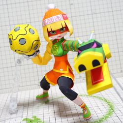 Rule 34 | 1girl, arms (game), beanie, black pantyhose, blonde hair, chinese clothes, domino mask, dragon, full body, green eyes, green footwear, hat, leggings, leggings under shorts, looking at viewer, mask, min min (arms), muumin (muumin craft), open mouth, orange shorts, pantyhose, papercraft (medium), photo (medium), shoes, short hair, shorts, solo, unconventional media