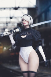 Rule 34 | 1girl, 2b (nier:automata), 2b (nier:automata) (cosplay), argentine (nationality), breasts, cleavage cutout, clothing cutout, cosplay, curvy, hair over one eye, hairband, highleg, highleg leotard, highres, holding, holding sword, holding weapon, leotard, lips, looking to the side, looking up, medium breasts, nier:automata, nier (series), photo (medium), real life, short hair, solo, sophie valentine, standing, sword, thick thighs, thighs, weapon, white hair, white leotard