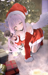 1girl absurdres angel_wings bell blue_archive blush breasts christmas christmas_tree commentary detached_sleeves dress feathered_wings gift hair_ornament hair_scrunchie halo hat highres holding holding_bell indoors kneeling large_breasts long_hair looking_at_viewer low_wings mika_(blue_archive) pink_hair pink_halo red_dress red_socks santa_costume santa_hat scrunchie socks solo wings yamada_auto yellow_eyes