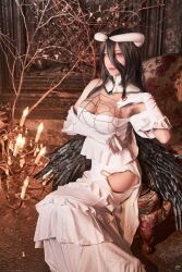 Rule 34 | 1girl, albedo (overlord), breasts, brown eyes, chandelier, cleavage, cosplay photo, detached collar, dress, gloves, hand on own chest, highres, hip vent, horns, looking at viewer, low wings, masyocos, medium breasts, off-shoulder dress, off shoulder, overlord (maruyama), photo (medium), sitting, smile, solo, white dress, white gloves, wings