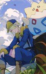 Rule 34 | 1boy, blonde hair, blue headwear, blue jumpsuit, boots, brown footwear, closed mouth, cloud, commentary request, creatures (company), day, from below, game freak, garchomp, gen 2 pokemon, gen 4 pokemon, grey eyes, hair over one eye, hat, highres, holding, hsin, jumpsuit, long sleeves, looking down, male focus, nintendo, outdoors, pokemon, pokemon (creature), pokemon legends: arceus, sky, smile, togepi, tree stump, volo (pokemon)